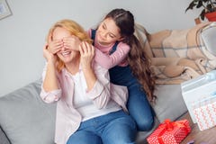 Ragazza di seduta di celebrazione della nonna e della nipote a casa che fa sorpresa per la nonna immagine stock Ragazza di seduta di celebrazione della nonna e della nipote a casa che fa sorpresa per la nonna immagine stock