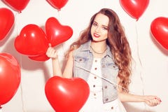 Ragazza di Valentine Beauty con gli aerostati rossi che ride, sul fondo bianco Bella giovane donna felice Il giorno della donna P fotografia stock libera da diritti Ragazza di Valentine Beauty con gli aerostati rossi che ride, sul fondo bianco Bella giovane donna felice Il giorno della donna P fotografia stock libera da diritti
