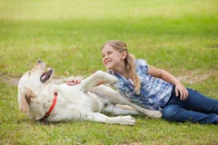 Ragazza felice che gioca con il cane di animale domestico al parco fotografia stock Ragazza felice che gioca con il cane di animale domestico al parco fotografia stock