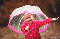 Ragazza felice del bambino che ride con un ombrello in pioggia immagine stock libera da diritti Ragazza felice del bambino che ride con un ombrello in pioggia immagine stock libera da diritti