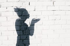 Ragazza graziosa che invia un bacio dell'aria intorno sui precedenti del muro di mattoni Immagini Stock Libere da Diritti Ragazza graziosa che invia un bacio dell'aria intorno sui precedenti del muro di mattoni Immagini Stock Libere da Diritti