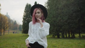 Ragazza graziosa con le pose alla moda di sguardo alla macchina fotografica al parco verde video d archivio Ragazza graziosa con le pose alla moda di sguardo alla macchina fotografica al parco verde video d archivio