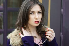 Ragazza graziosa premurosa in cappotto blu con i vetri immagine stock libera da diritti Ragazza graziosa premurosa in cappotto blu con i vetri immagine stock libera da diritti
