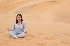 Ragazza indonesiana nella posizione del loto sulla duna 7, baia di Walvis, Namibia Fotografie Stock Libere da Diritti Ragazza indonesiana nella posizione del loto sulla duna 7, baia di Walvis, Namibia Fotografie Stock Libere da Diritti