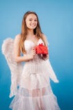 Ragazza innocente con le ali di angelo che stanno con l'arco e la freccia contro il fondo bianco isolato Angelo teenager Giorno d fotografia stock libera da diritti Ragazza innocente con le ali di angelo che stanno con l'arco e la freccia contro il fondo bianco isolato Angelo teenager Giorno d fotografia stock libera da diritti