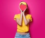 Ragazza in maglietta gialla con la scatola di forma del cuore fotografie stock libere da diritti Ragazza in maglietta gialla con la scatola di forma del cuore fotografie stock libere da diritti