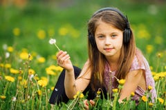 Ragazza sveglia in cuffie che gode della musica in natura fotografia stock Ragazza sveglia in cuffie che gode della musica in natura fotografia stock