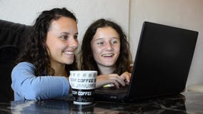 Ragazze teenager che esaminano computer portatile archivi video Ragazze teenager che esaminano computer portatile archivi video