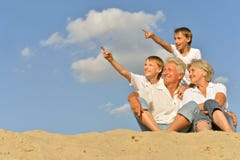 Ragazzi con i nonni che si siedono sulla sabbia fotografia stock Ragazzi con i nonni che si siedono sulla sabbia fotografia stock