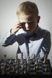 Ragazzino che gioca scacchi Piccolo bambino astuto del genio Gioco intelligente Scacchiera immagini stock Ragazzino che gioca scacchi Piccolo bambino astuto del genio Gioco intelligente Scacchiera immagini stock