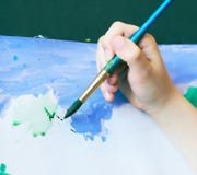 Ragazzino che impara concetto di arte del disegno della pittura La mano del bambino tiene una spazzola e le pitture su Libro Bian Immagine Stock Libera da Diritti Ragazzino che impara concetto di arte del disegno della pittura La mano del bambino tiene una spazzola e le pitture su Libro Bian Immagine Stock Libera da Diritti
