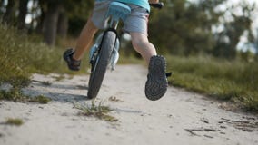 Ragazzo che cicla una bici di funzionamento stock footage Ragazzo che cicla una bici di funzionamento stock footage