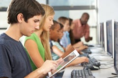 Ragazzo che utilizza la compressa di Digital nella classe del computer immagini stock Ragazzo che utilizza la compressa di Digital nella classe del computer immagini stock