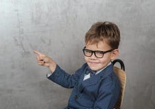 Ragazzo europeo sveglio in un rivestimento con i punti di una farfalla il suo dito alla parete immagini stock libere da diritti Ragazzo europeo sveglio in un rivestimento con i punti di una farfalla il suo dito alla parete immagini stock libere da diritti