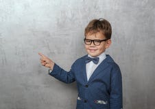 Ragazzo europeo sveglio in un rivestimento con i punti di una farfalla il suo dito alla parete immagini stock libere da diritti Ragazzo europeo sveglio in un rivestimento con i punti di una farfalla il suo dito alla parete immagini stock libere da diritti
