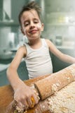 Ragazzo sorridente che impasta la pasta Immagini Stock Ragazzo sorridente che impasta la pasta Immagini Stock