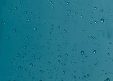 Rain drops, water drops of rain on a window glass with blurred dark blue background Royalty Free Stock Photo Rain drops, water drops of rain on a window glass with blurred dark blue background Royalty Free Stock Photo