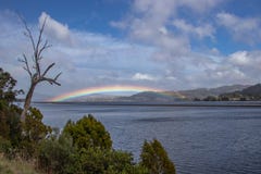 Rainbow over land at Kangaroo Bay, Tasmania stock photos Rainbow over land at Kangaroo Bay, Tasmania stock photos