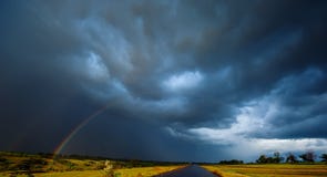 Rainbow In The Field Rain And Dark Clouds. Spring Season, Evening. Royalty Free Stock Photos