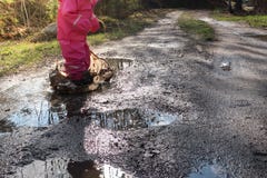 Ребенок/девушка с водным бассейном/лужицей розового rainwear скача стоковая фотография Ребенок/девушка с водным бассейном/лужицей розового rainwear скача стоковая фотография