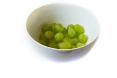 Raisins dans une cuvette sur le fond blanc images libres de droits Raisins dans une cuvette sur le fond blanc images libres de droits