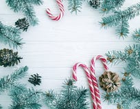 Rama de árbol de navidad, pinecone, caramelo decorativo festivo de la nieve en una tarjeta de madera blanca del fondo fotos de archivo libres de regalías Rama de árbol de navidad, pinecone, caramelo decorativo festivo de la nieve en una tarjeta de madera blanca del fondo fotos de archivo libres de regalías