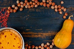 Rama dekoracja dla dziękczynienie torta lub kulebiaka: bania, tarta, goji jagoda, hazelnuts na czarnym drewnianym tle zdjęcia stock Rama dekoracja dla dziękczynienie torta lub kulebiaka: bania, tarta, goji jagoda, hazelnuts na czarnym drewnianym tle zdjęcia stock