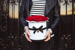 Ramo de rosas rojas en una caja en las manos de una muchacha fotos de archivo libres de regalías Ramo de rosas rojas en una caja en las manos de una muchacha fotos de archivo libres de regalías
