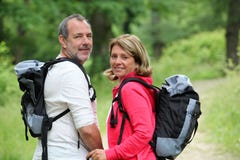Randonneurs de sourire dans la forêt appréciant le voyage photographie stock Randonneurs de sourire dans la forêt appréciant le voyage photographie stock
