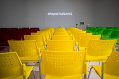 Rangées prêtes à employer des chaises colorées dans la salle de conférence avec le wor photos libres de droits Rangées prêtes à employer des chaises colorées dans la salle de conférence avec le wor photos libres de droits