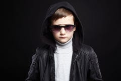 Rapaz pequeno elegante no hoodie e nos óculos de sol foto de stock Rapaz pequeno elegante no hoodie e nos óculos de sol foto de stock