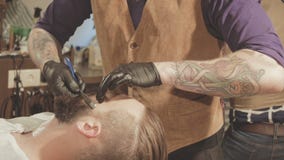 Rasage du processus des barbes dans le raseur-coiffeur Le maître fait un client de barbe de coupe de cheveux avec le rasoir droit banque de vidéos Rasage du processus des barbes dans le raseur-coiffeur Le maître fait un client de barbe de coupe de cheveux avec le rasoir droit banque de vidéos