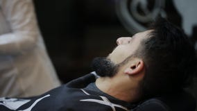 Rasage du processus des barbes dans le raseur-coiffeur Le maître fait un client de barbe de coupe de cheveux avec le rasoir droit banque de vidéos Rasage du processus des barbes dans le raseur-coiffeur Le maître fait un client de barbe de coupe de cheveux avec le rasoir droit banque de vidéos