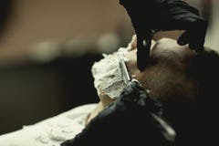 Rasatura dell'uomo un rasoio diritto vicino su con le mani immagini stock libere da diritti Rasatura dell'uomo un rasoio diritto vicino su con le mani immagini stock libere da diritti