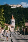 RASNOV, ΡΟΥΜΑΝΊΑ - 1 ΑΥΓΟΎΣΤΟΥ 2017: Κεντρικός δρόμος της αρχαίας σαξονικής πόλης τη φωτεινή ηλιόλουστη ημέρα Ενισχυμένη εκκλησία στοκ φωτογραφίες με δικαίωμα ελεύθερης χρήσης RASNOV, ΡΟΥΜΑΝΊΑ - 1 ΑΥΓΟΎΣΤΟΥ 2017: Κεντρικός δρόμος της αρχαίας σαξονικής πόλης τη φωτεινή ηλιόλουστη ημέρα Ενισχυμένη εκκλησία στοκ φωτογραφίες με δικαίωμα ελεύθερης χρήσης