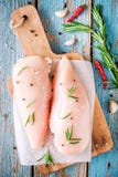 Raw chicken fillet with garlic, pepper and rosemary on rustic background royalty free stock photos Raw chicken fillet with garlic, pepper and rosemary on rustic background royalty free stock photos