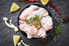 Raw Chicken Wings With Lemon Chilli Herbs And Spices And Mushroom On Black Plate Top View - Raw Uncooked Chicken Meat Marinated Royalty Free Stock Images