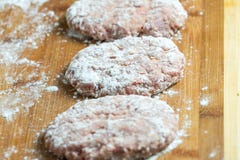 Raw cutlets of minced meat on the cutting Board. Sprinkle with flour. stock image Raw cutlets of minced meat on the cutting Board. Sprinkle with flour. stock image