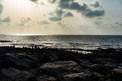 Rayons de soleil des nuages et d'une plage rocheuse images stock Rayons de soleil des nuages et d'une plage rocheuse images stock
