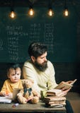 Reading concept. Teacher reading book to school boy. Little child listen to man reading book in class. Keep reading stock images Reading concept. Teacher reading book to school boy. Little child listen to man reading book in class. Keep reading stock images