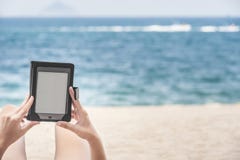 Reading From E-reader On The Beach Stock Photography