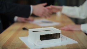 Real estate agent and customer signing a contract, the woman is buying a new home, model house in the foreground. stock video Real estate agent and customer signing a contract, the woman is buying a new home, model house in the foreground. stock video