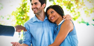 Real estate agent giving house keys to couple stock photo Real estate agent giving house keys to couple stock photo