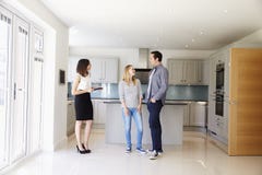 Realtor που παρουσιάζει νέο ζεύγος γύρω από την ιδιοκτησία για την πώληση στοκ εικόνες Realtor που παρουσιάζει νέο ζεύγος γύρω από την ιδιοκτησία για την πώληση στοκ εικόνες