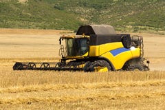 Reaping machine or harvester combine on a wheat field with a very dynamic sky as background Stock Photography Reaping machine or harvester combine on a wheat field with a very dynamic sky as background Stock Photography