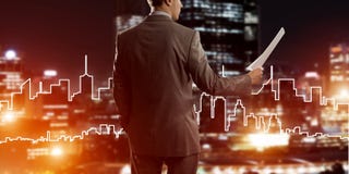 Man architect or engineer presenting construction concept and holding documents in hand stock photo Man architect or engineer presenting construction concept and holding documents in hand stock photo