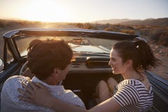 Rear View Of Couple On Road Trip Driving Classic Convertible Car Towards Sunset royalty free stock photo Rear View Of Couple On Road Trip Driving Classic Convertible Car Towards Sunset royalty free stock photo