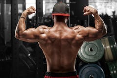 Rear view muscular man posing in gym, showing back and biceps. Strong male naked torso, working out royalty free stock photo Rear view muscular man posing in gym, showing back and biceps. Strong male naked torso, working out royalty free stock photo