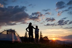 Rear View Of Mother Hugs Her Son Near Tent On Top Of Mountain Enjoying View Of Sun Stock Image