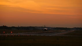 Twin engine turboprop airplane landing at sunrise stock footage Twin engine turboprop airplane landing at sunrise stock footage